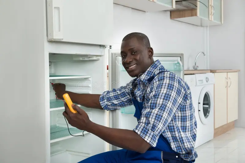 Technicien réparant un réfrigérateur